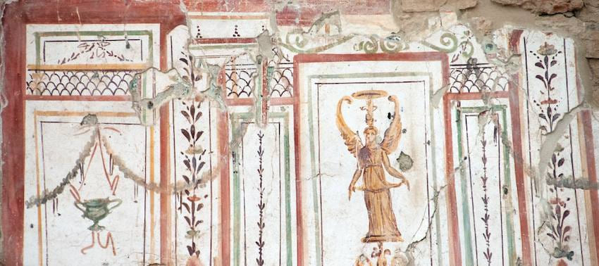Fresco romano de las Casas Adosadas de Éfeso con una figura femenina alada pintada entre paneles enmarcados en rojo y verde