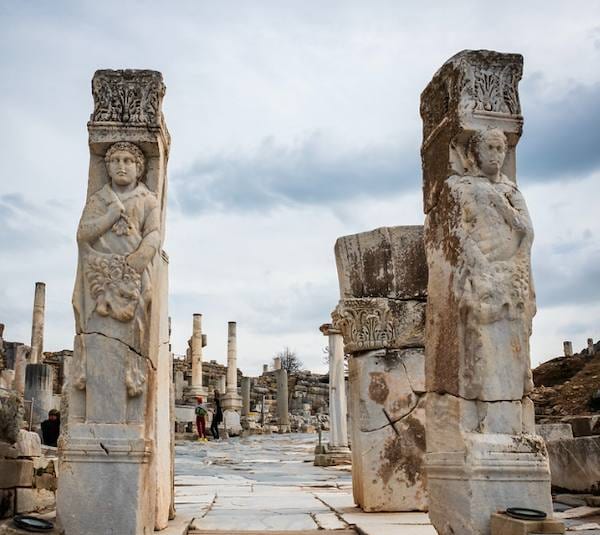 Los dos pilares de la Puerta de Heracles en Éfeso, tallados con el héroe envuelto en la piel del león, y la calle de los Curetes al fondo